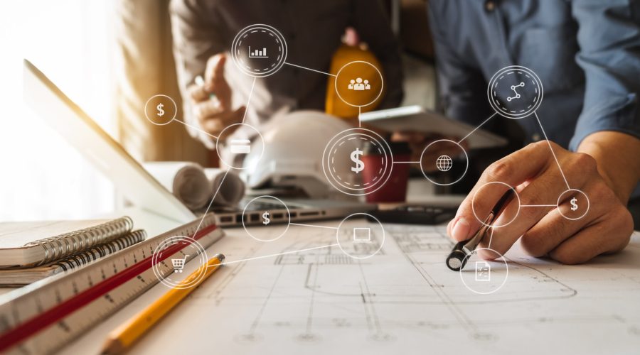 Two colleagues discussing data working and tablet, laptop with on on architectural project at construction site at desk in office